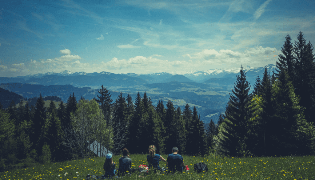 Family eating a picnic in a clearing in the woods